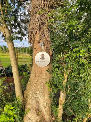 a sign on the side of a tree at The Hideaway Retreat in Omagh