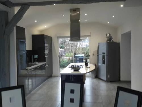 - une cuisine avec un îlot au milieu d'une pièce dans l'établissement maison à la campagne prés de la ville, à Aiglemont