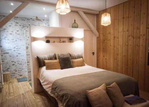 - une chambre avec un grand lit et deux lumières dans l'établissement L'Essentiel, à Gujan-Mestras