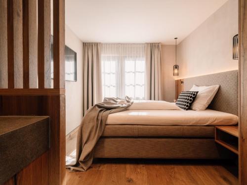 a bedroom with a bed with a window at JOHANN Schladming in Schladming