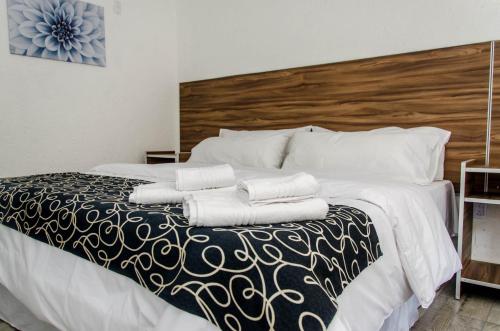 a bedroom with a bed with two towels on it at La Reina Hotel in Santa Rosa de Calamuchita
