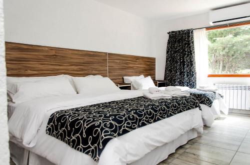 a bedroom with a large bed and a window at La Reina Hotel in Santa Rosa de Calamuchita