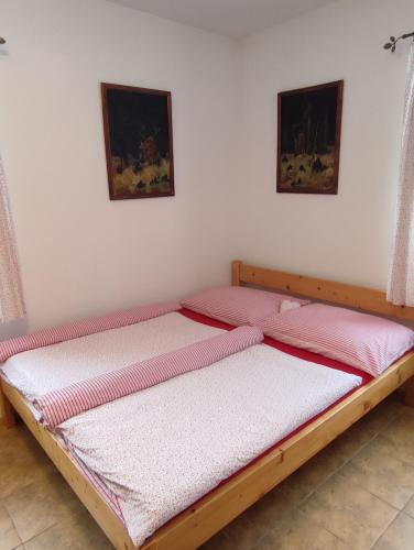 two twin beds in a bedroom with two pictures on the wall at Apartmány Hájenka in Vápenka