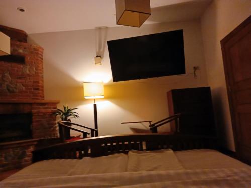 a bedroom with a bed and a flat screen tv at Hotel Polak in Zamość