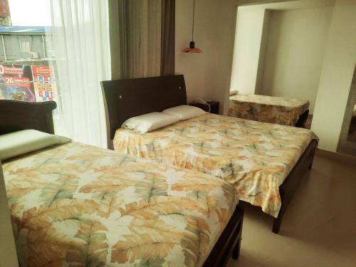 a bedroom with two beds and a window at Hotel La Sultana Tumaco in Tumaco