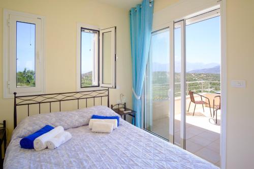 a bedroom with a bed with towels and a balcony at Villa Poppy in Vathi
