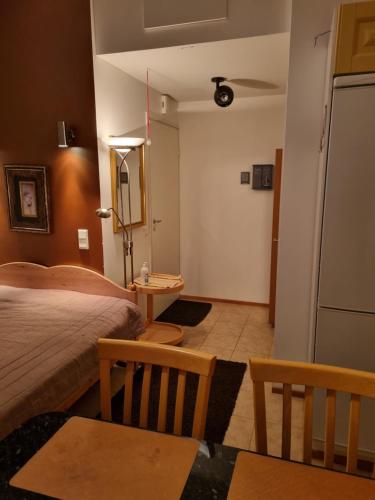 Apartment Oulu Varjakka في Oulunsalo: غرفة نوم بسرير وطاولة وثلاجة