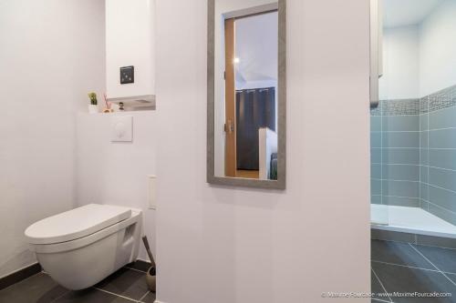 a white bathroom with a toilet and a mirror at Le BLUE BAY--T2--TOUT CONFORT--HYPER CENTRE--WIFI in Tarbes