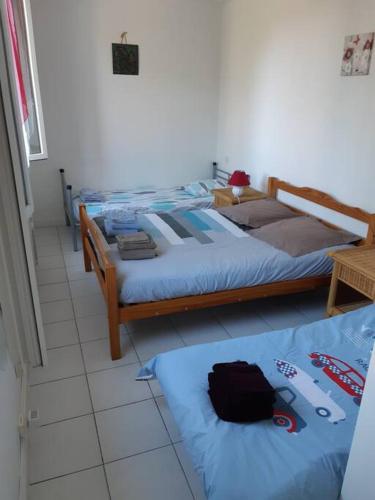 a bedroom with two beds with blue sheets at T2 calme, tout confort proche St Emilion/Bordeaux in Les Peintures