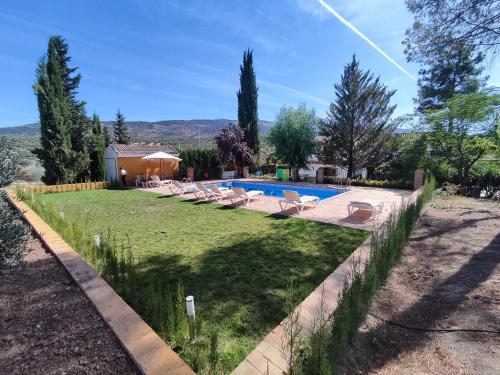 un patio trasero con piscina y tumbonas en Paredejas del Rey, en Priego de Córdoba