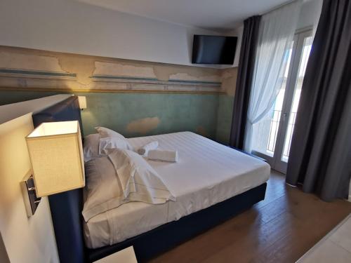 a bedroom with a bed with a television on the wall at Hotel Boutique Castiglione del Lago in Castiglione del Lago