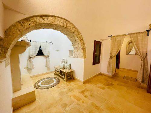 an archway in a room with a table and a rug at TRULLO FERNANDO in San Michele Salentino