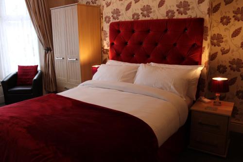 ブラックプールにあるMardonia Hotelのベッドルーム1室(赤いヘッドボード付きの大型ベッド1台付)