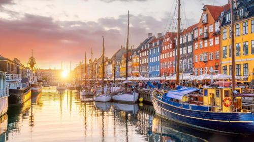 a group of boats docked in a canal with buildings at Perfect Apartments in Superb Location by Strøget, the Metro & Attractions in Copenhagen
