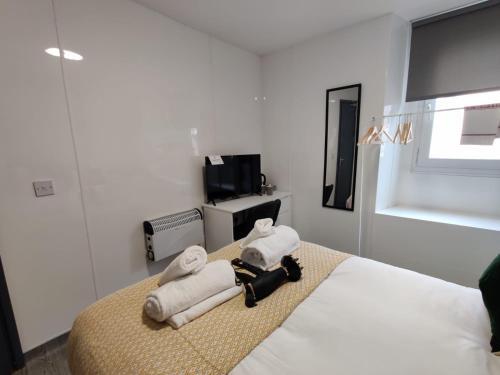 a hotel room with a bed with towels on it at Double Ensuite Rooms in Swansea