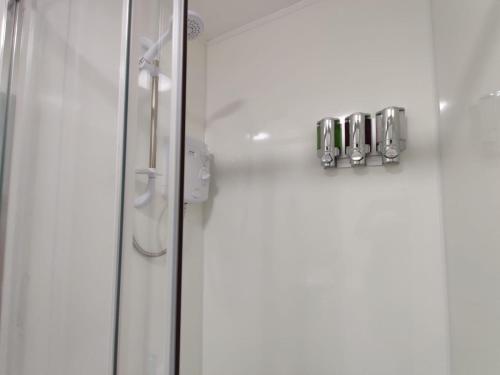 a shower with a glass door in a bathroom at Double Ensuite Rooms in Swansea