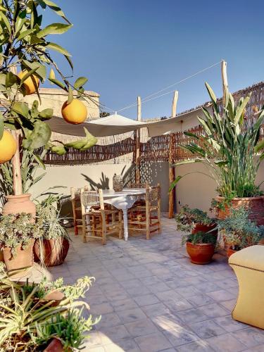 a patio with a table and a bunch of plants at Riad Dar Chacha in Marrakech