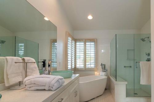 a bathroom with a tub and a shower and a sink at Sunset Disco: Large Pool/Spa @ Lush Family Retreat in La Quinta