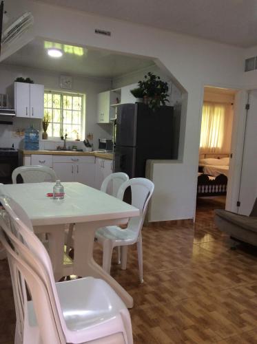 cocina con mesa blanca y sillas blancas en Casa D' Linda, en San Andrés
