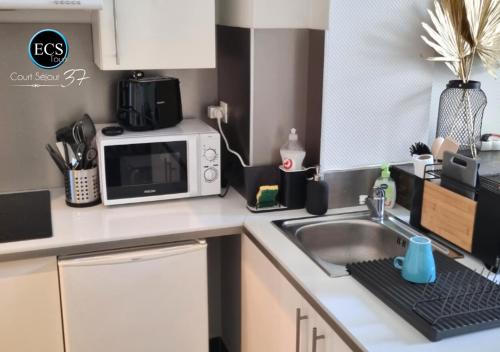 une cuisine avec un évier et un micro-ondes dans l'établissement 