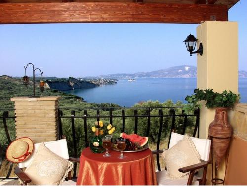 a table on a balcony with a view of the water at Athenea Villas, Private Pools & Gardens in Keri