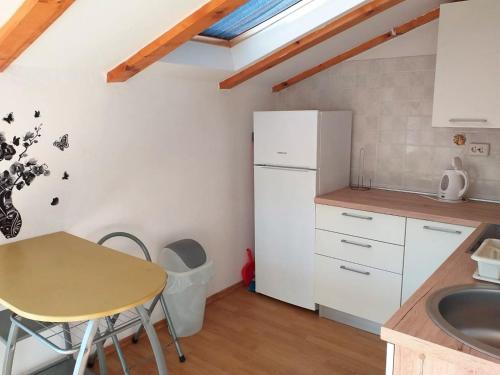 a kitchen with a table and a white refrigerator at House Lopin in Žuljana