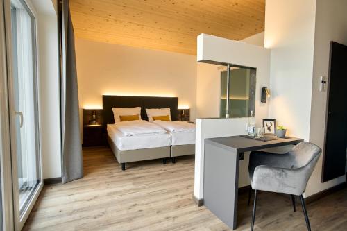 a bedroom with a bed and a desk with a chair at Hotel Kapelle in Radolfzell am Bodensee