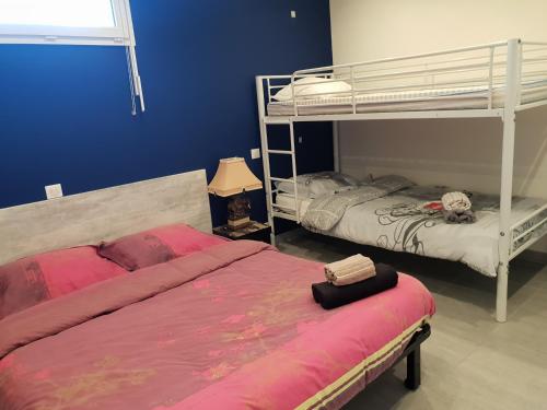 a bedroom with two bunk beds and a lamp at meublé au calme à 1 minute de la plage in Banyuls-sur-Mer