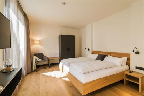 a bedroom with a large white bed and a television at WeinQuartier Bissersheim in Bissersheim