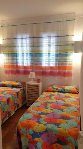 1 dormitorio con 2 camas con sombrillas en Mágico Apartamento Duplex Sota el Campanar, en Cadaqués