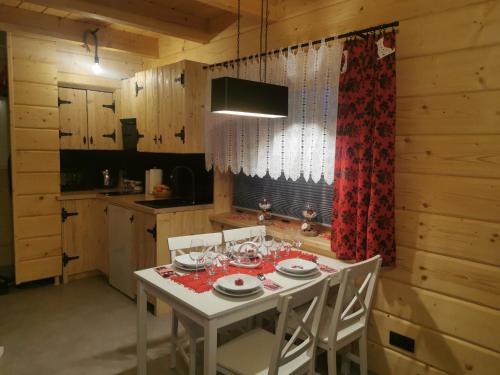 cocina con mesa blanca con sillas y comedor en DOMEK NA WIERCHU en Kluszkowce