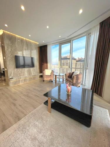 a living room with a couch and a table and a tv at VIP Apartment 120m2 with Panoramic windows, 22 floor. OBOLON in Kyiv