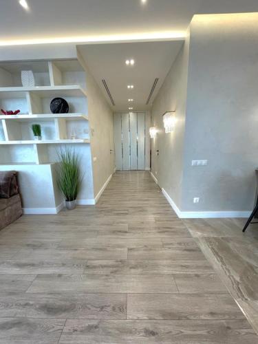 an empty room with a hallway with white shelves at VIP Apartment 120m2 with Panoramic windows, 22 floor. OBOLON in Kyiv