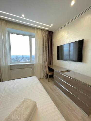 a bedroom with a television and a desk and a bed at VIP Apartment 120m2 with Panoramic windows, 22 floor. OBOLON in Kyiv