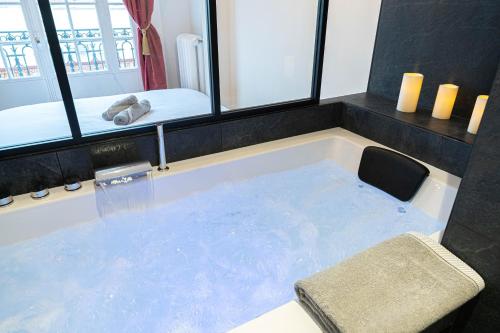 a bath tub filled with blue water next to a bed at Jacuzzi-Nice quartier des musiciens-Loft in Nice