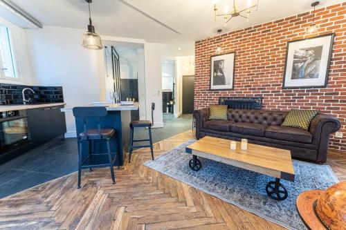 un salon avec un canapé et un mur de briques dans l'établissement Jacuzzi-Nice quartier des musiciens-Loft, à Nice
