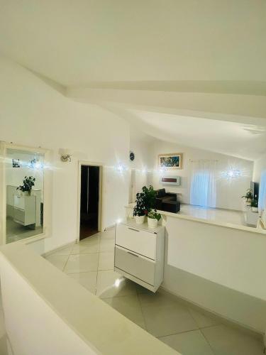 a white kitchen with a counter and a sink at Apartments EDEN in Šišan
