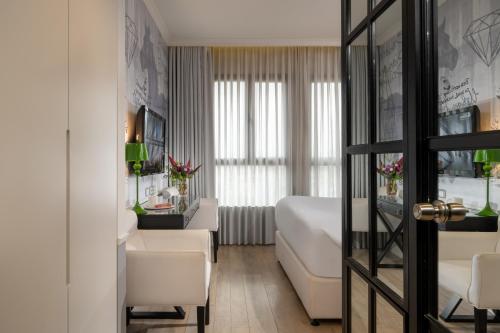 a hotel room with a bed and a desk at Hotel Indigo Tel Aviv - Diamond District by IHG in Tel Aviv