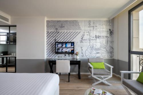 a bedroom with a desk and a drawing on the wall at Hotel Indigo Tel Aviv - Diamond District by IHG in Tel Aviv