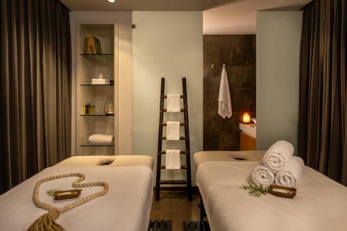 a hotel room with two beds with towels on them at Hotel Indigo Tel Aviv - Diamond District by IHG in Tel Aviv
