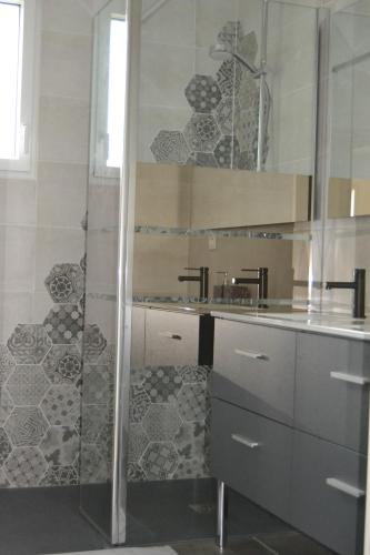 La salle de bains est pourvue d'une douche et d'un lavabo. dans l'établissement Maison en bord de mer au Domaine du Bois Soret, à Notre-Dame-de-Monts