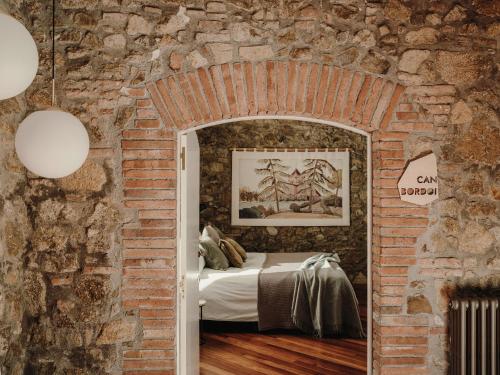 Dormitorio con paredes de ladrillo y cama en una habitación de ladrillo en Paratgea, en Llinars del Vallès