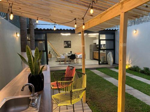 a patio with a sink and chairs under a pergola at La Terraza Home in Guadalajara