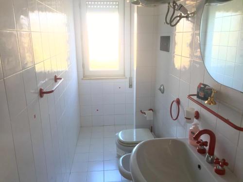 a white bathroom with a toilet and a sink at Casamare San Giorgio in Sciacca