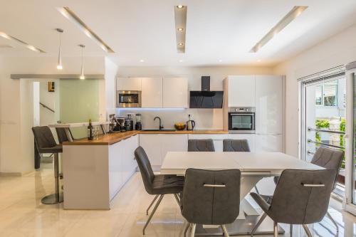 a kitchen and dining room with a table and chairs at Private seaside Morska Villa with pool in Baška Voda, Dalmatia, Croatia in Baška Voda