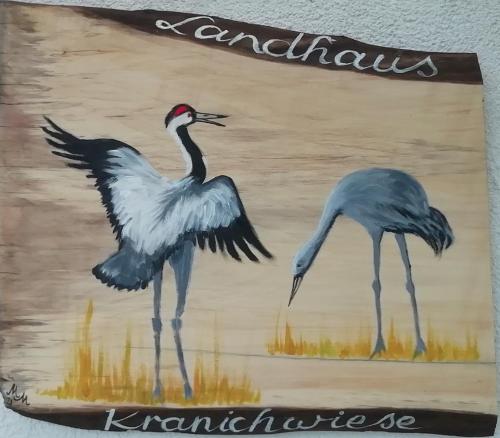 a painting of two birds standing next to each other at Landhaus Kranichwiese in Göhren-Lebbin