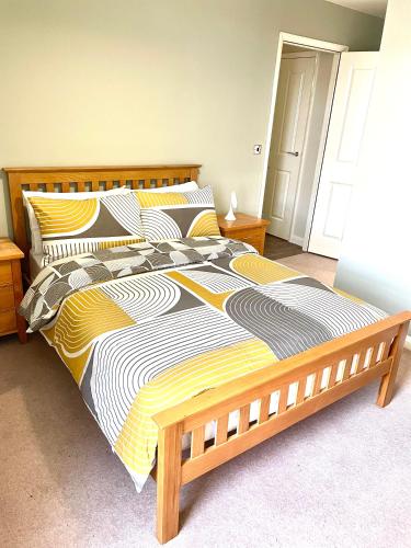 a bedroom with a large bed with a wooden frame at Luxurious two-bedroom apartment in the centre of Peterborough in Peterborough