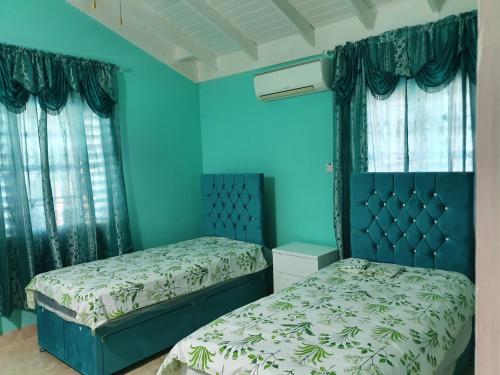 B&B Sunshine في فالماوث: غرفة نوم بسريرين وجدران زرقاء