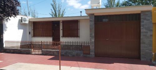 una casa con dos puertas de garaje en una calle en Casa EL HORNERO con cochera en gran Mendoza en Godoy Cruz