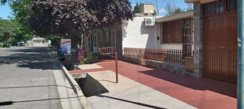 a street with a sign on the sidewalk next to a building at Casa EL HORNERO con cochera en gran Mendoza in Godoy Cruz